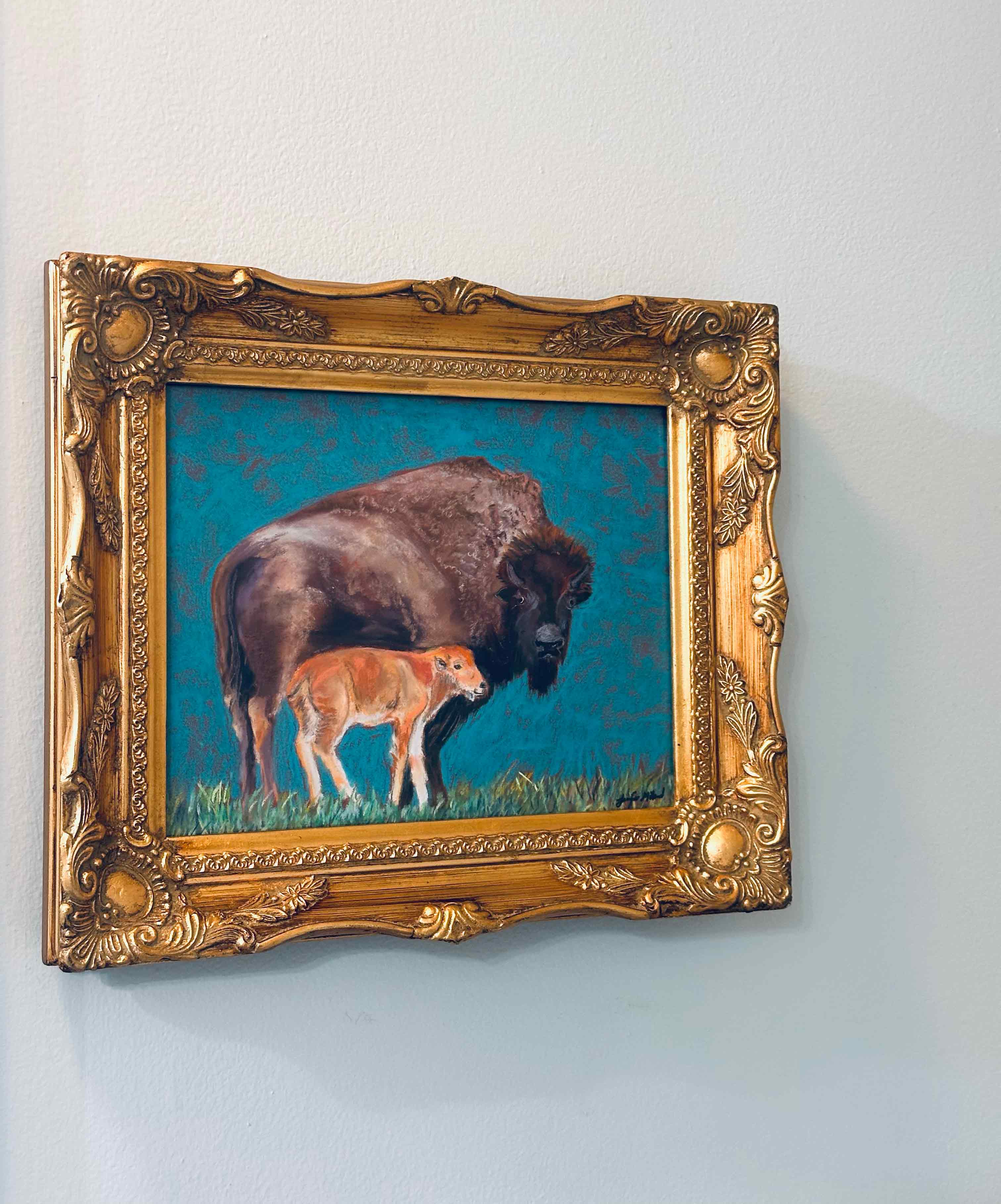 Henrietta and Clover, the mother/son duo are two bisons that the artist painted in this colorful soft pastel painting, framed in an ornate gold vintage frame.