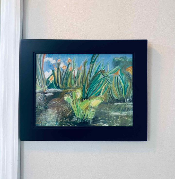 A photo of this original artwork of a venus fly trap in a black frame behind glass.