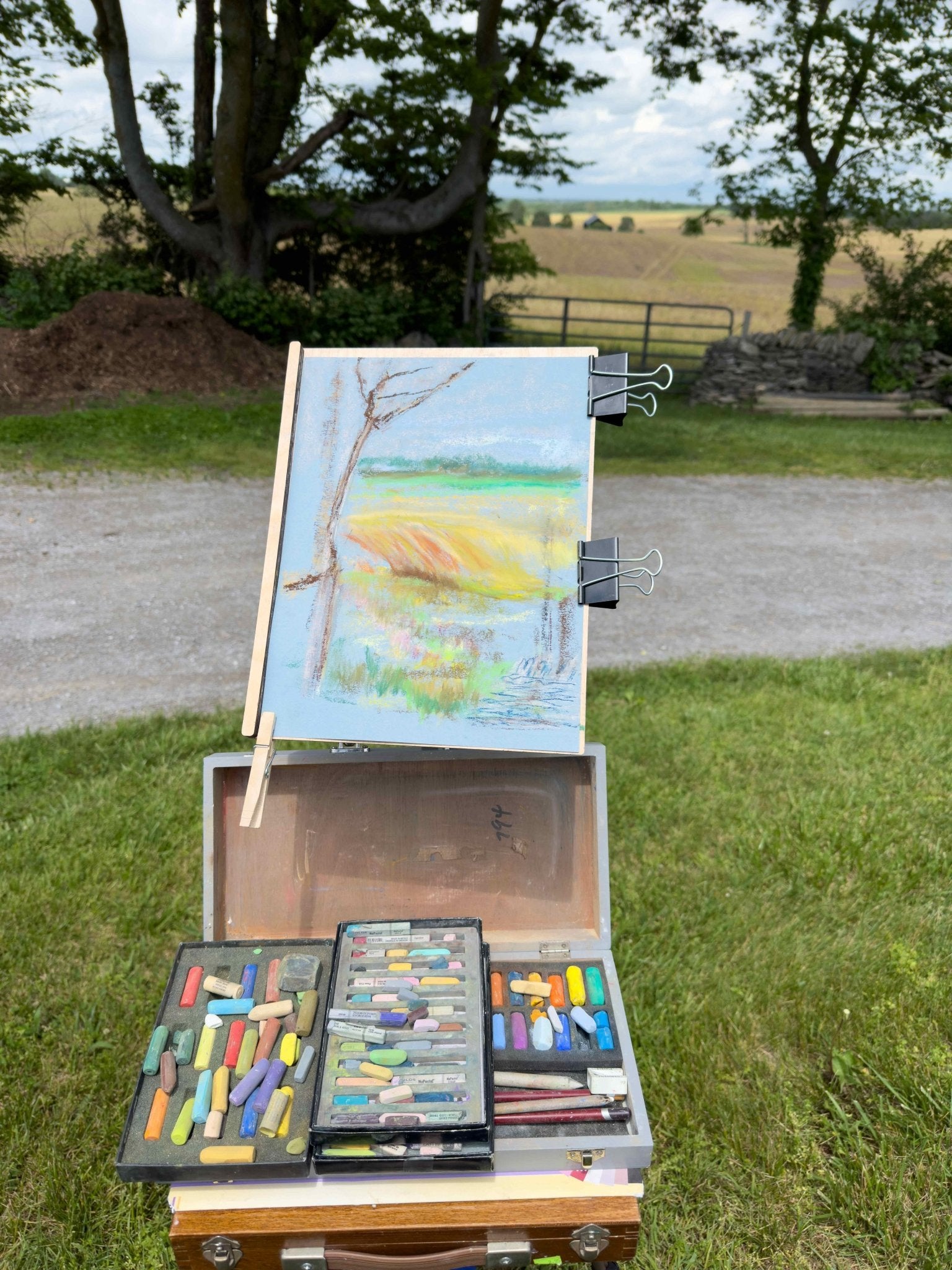 The beginning of a plein air painting of a farm in the countryside.