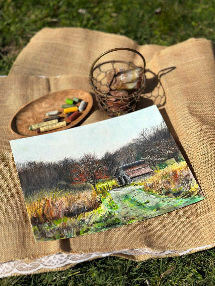 A photo of the original oil pastel of a barn and road off Twin Creek Road in Estill County, Kentucky on a burlap sack with props.
