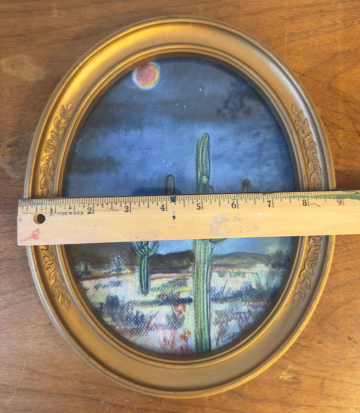 This vintage gold frame holding a soft pastel print of the desert at night is measured with a ruler at almost 9" in width.