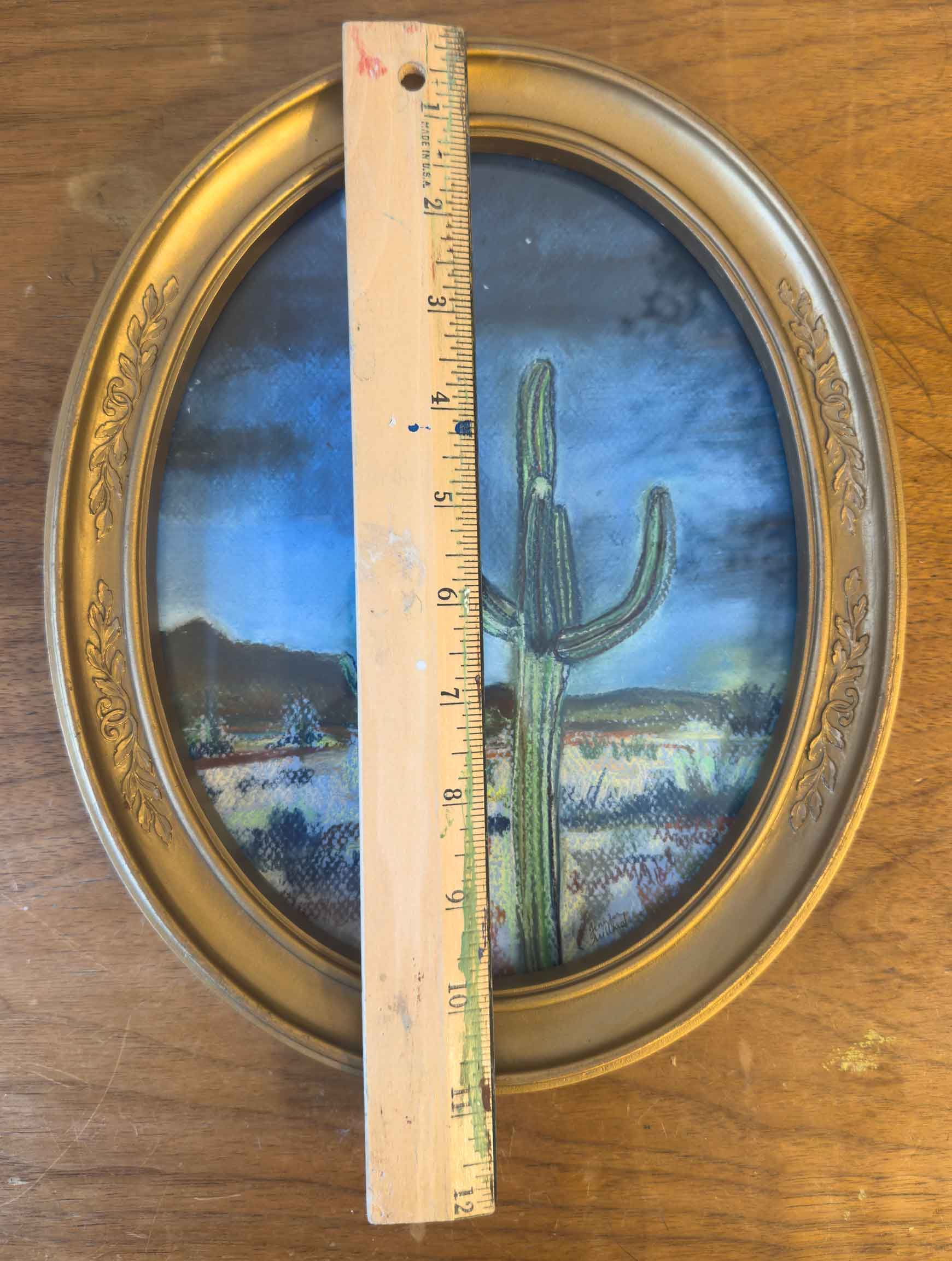This vintage gold frame holding a soft pastel print of the desert at night is measured with a ruler at almost 11" in height.