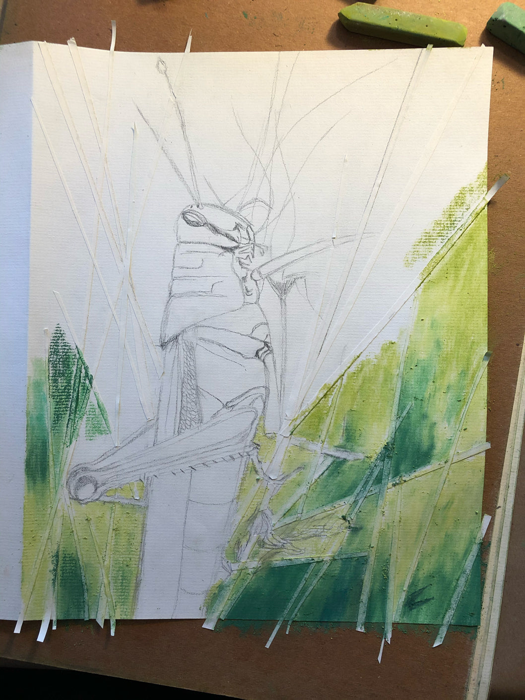 The process of painting uses tape strips to block out straight strands of grass around a grasshopper.