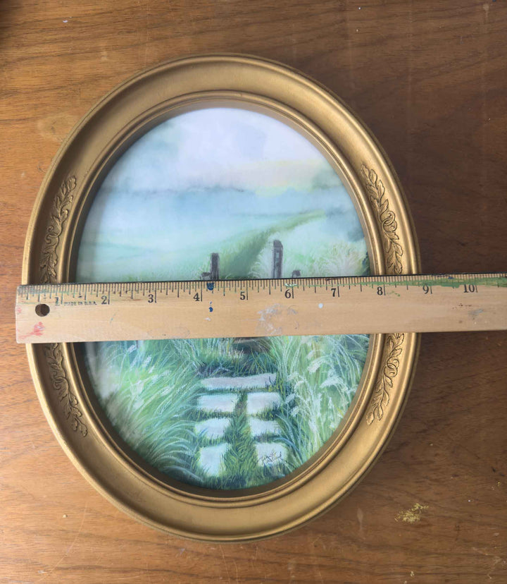 This print in an vintage oval frame is measured with a ruler at almost 9" in width.